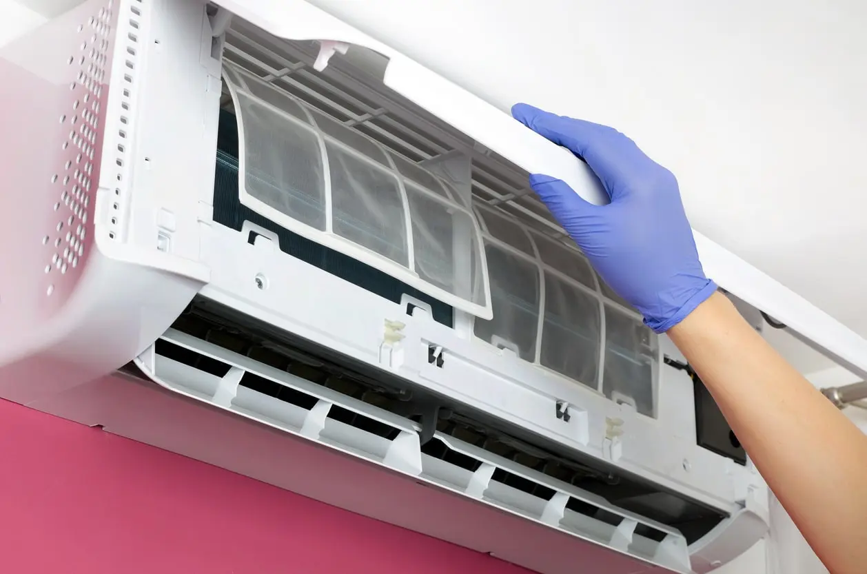 A technician working on air conditioner, performing necessary repairs and adjustments.